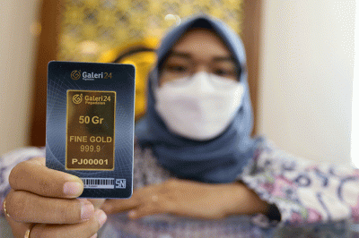 Petugas menunjukan emas batangan di Galeri 24 Pegadaian, Jakarta, Selasa (29/3/2022).