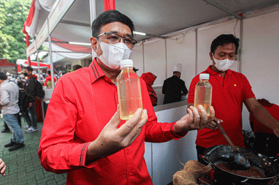 Kader Partai Demokrasi Indonesia Perjuangan (PDIP) menunjukan hasil olahan minyak kelapa saat acara demo masak tanpa minyak goreng.