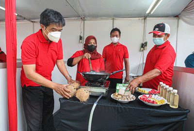 Kader Partai Demokrasi Indonesia Perjuangan (PDIP) menunjukan hasil olahan minyak kelapa saat acara demo masak tanpa minyak goreng.
