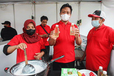 Kader Partai Demokrasi Indonesia Perjuangan (PDIP) menunjukan hasil olahan minyak kelapa saat acara demo masak tanpa minyak goreng.