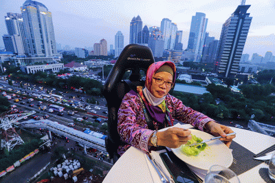 Pengunjung menyantap hidangan di Lounge In The Sky, Jakarta, Selasa (29/3/2022).