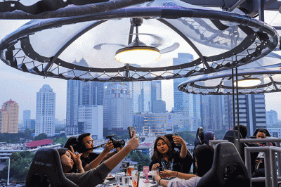 Pengunjung menyantap hidangan di Lounge In The Sky, Jakarta, Selasa (29/3/2022).