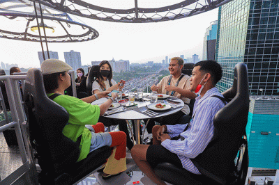 Pengunjung menyantap hidangan di Lounge In The Sky, Jakarta, Selasa (29/3/2022).