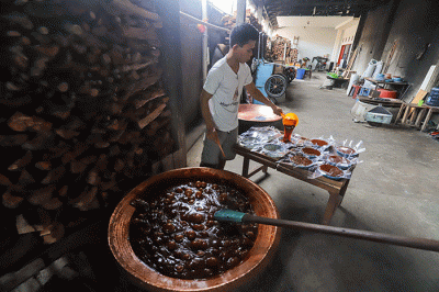 Pekerja mengaduk dodol dalam kuali di rumah produksi Dodol Betawi Sari Rasa Ibu Yuyun, Jakarta Selatan, Rabu (30/3/2022).