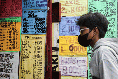 Penjual menunjukkan kartu perdana di konter pulsa kawasan Jakarta Timur, Jumat (1/4/2022).
