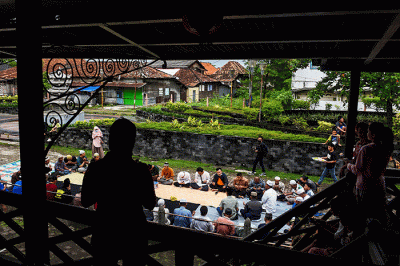 Warga Muslim Kampung Kapitan melaksanakan acara sedekah Kampung Kapitan di depan rumah Kapitan pinggiran Sungai Musi.