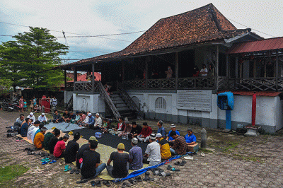Warga Muslim Kampung Kapitan melaksanakan acara sedekah Kampung Kapitan di depan rumah Kapitan pinggiran Sungai Musi.