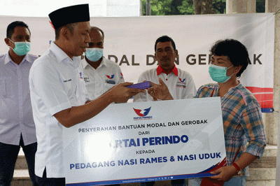 Ketua DPP Partai Perindo Bidang Organisasi dan Kaderisasi Yusuf Lakaseng menyerahkan bantuan gerobak dan bantuan uang  secara simbolik.