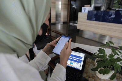 Pekerja kantoran saat membuka aplikasi KAI Access untuk membeli tiket kereta mudik di kawasan Jakarta Pusat, Senin (4/4/2022).
