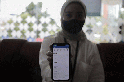 Pekerja kantoran saat membuka aplikasi KAI Access untuk membeli tiket kereta mudik di kawasan Jakarta Pusat, Senin (4/4/2022).