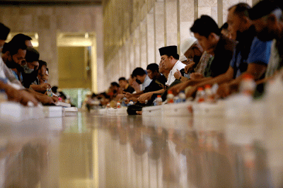 Sejumlah umat Islam bersiap menyantap sajian berbuka puasa di kompleks Masjid Istiqlal, Jakarta, Senin (4/4/2022).