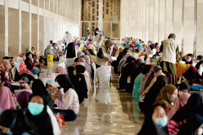 Sejumlah umat Islam bersiap menyantap sajian berbuka puasa di kompleks Masjid Istiqlal, Jakarta, Senin (4/4/2022).