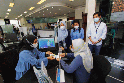 Presiden Direktur Yuli Melati Suryaningrum (Tengah) dan Direktur Lukman Hadiwijaya berkomunikasi dengan nasabah di Teller Kantor Cabang Bank BCA Syariah.