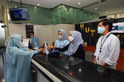 Presiden Direktur Yuli Melati Suryaningrum (Tengah) dan Direktur Lukman Hadiwijaya berkomunikasi dengan nasabah di Teller Kantor Cabang Bank BCA Syariah.