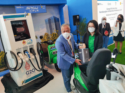 General Manager PLN UID Jakarta Raya, Doddy B. Pangaribuan (kiri) bersama Direktur PT Sepeda Untuk Indonesia Iki Sari Dewi mengganti bateri untuk motor listrik.