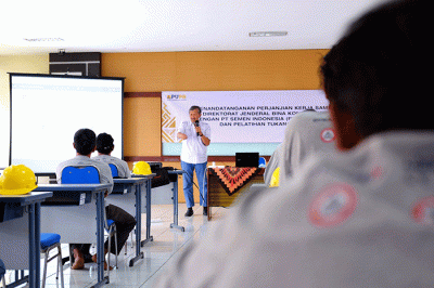 Direktur Utama SIG, Donny Arsal (kiri) menyerahkan Alat Pelindung Diri sebagai tanda dimulainya pelatihan untuk tenaga konstruksi.
