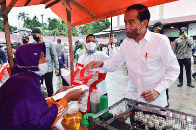 Presiden Joko Widodo didampingi Ibu Negara Iriana Joko Widodo berbincang dengan pedagang makanan saat kunjungan kerja ke Pasar Modern Angso Duo di Jambi.