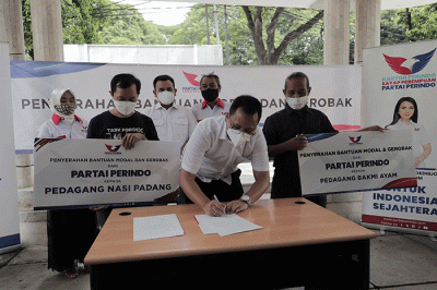 Ketua DPP Partai Perindo Bidang Hukum dan HAM Tama S Langkun menyerahkan bantuan gerobak kepada penerima bantuan pedagang nasi padang dan bakmi ayam.