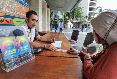 Warga saat membayar zakat di Stand Pelayanan Zakat Masjid Istiqlal, Jakarta Pusat, Minggu, (10/4/2022).