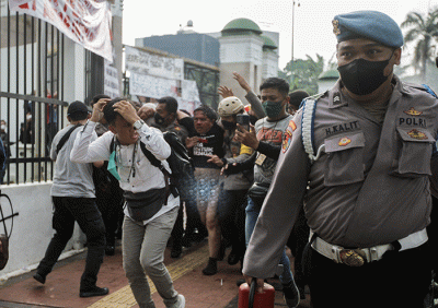 Anggota polisi mengevakuasi Ketua Pergerakan Indonesia untuk Semua (PIS) Ade Armando dari massa aksi 11 April di kawasan gedung DPR, Jakarta, Senin (11/4/2022).