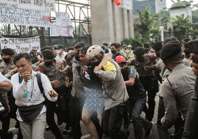 Anggota polisi mengevakuasi Ketua Pergerakan Indonesia untuk Semua (PIS) Ade Armando dari massa aksi 11 April di kawasan gedung DPR, Jakarta, Senin (11/4/2022).