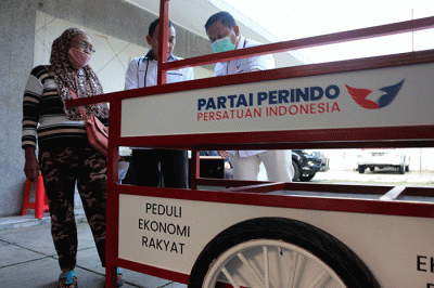 Bantuan gerobak serta modal secara simbolik kepada Ibu Mayem pedagang sayur dan Bapak Rukmanan Pedagang Siomai saat Penyerahan di Kantor DPP Partai Perindo.