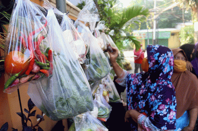 Warga mengambil sayuran, lauk pauk dan baju bekas gratis hasil sumbangan Warga RT 002 RW 04 dan para donatur di Jalan Jati Padang VI, Jakarta.