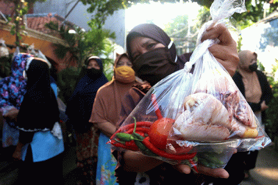 Warga mengambil sayuran, lauk pauk dan baju bekas gratis hasil sumbangan Warga RT 002 RW 04 dan para donatur di Jalan Jati Padang VI, Jakarta.