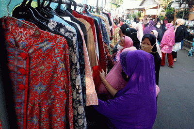 Warga mengambil sayuran, lauk pauk dan baju bekas gratis hasil sumbangan Warga RT 002 RW 04 dan para donatur di Jalan Jati Padang VI, Jakarta.