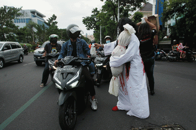 Aksi sekumpulan orang berkostum hantu yang tergabung dalam komunitas Semarangker membagi-bagikan takjil kepada pengguna jalan.