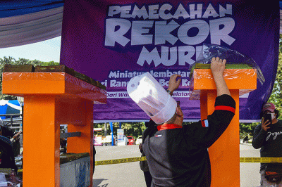 321 loyang Bolu Kojo yang dibuat anggota Badan Kerjasama Organisasi Wanita (BKOW) Sumsel yang diletakan pada miniatur Jembatan Ampera.