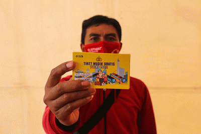 Warga menunjukkan tiket mudik gratis Lebaran 2022 di depan Gedung Balai Pertemuan Metro Jaya, Polda Metro Jaya, Jakarta Selatan, Sabtu (23/4/2022).