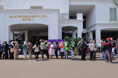 Warga menunjukkan tiket mudik gratis Lebaran 2022 di depan Gedung Balai Pertemuan Metro Jaya, Polda Metro Jaya, Jakarta Selatan, Sabtu (23/4/2022).