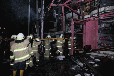 Petugas pemadam kebakaran berusaha memadamkan kobaran api yang membakar kios dan rumah warga di kawasan Pasar Gembrong, Jatinegara, Jakarta Timur.