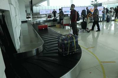 Sejumlah penumpang turun dari pesawat berjalan menuju terminal kedatangan di Bandara Internasional Jenderal Ahmad Yani, Kota Semarang, Jawa Tengah.