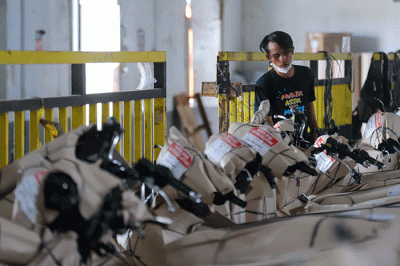 Petugas mengemas motor sebelum dikirim menggunakan kereta di Stasiun Kereta Api Logistik, Kampung Bandan, Jakarta Utara, Selasa (26/4/2022).