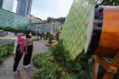 Warga berswafoto dengan latar belakang ornamen bernuansa lebaran yang terpasang di kawasan Bundaran HI, Jakarta Pusat, Selasa (26/4/2022).
