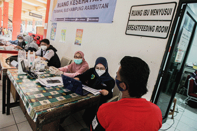 Pemudik saat menerima suntikan vaksinasi booster di Posko Kesehatan Terminal Kampung Rambutan, Jakarta Timur, Rabu (27/4/2022).
