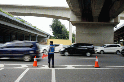 Petugas mengatur lalu lintas di depan pintu masuk tol layang MBZ yang ditutup situasional, Bekasi, Jawa Barat, Kamis (28/4/2022).
