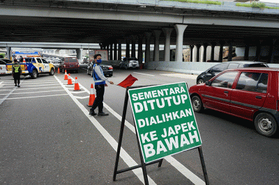 Petugas mengatur lalu lintas di depan pintu masuk tol layang MBZ yang ditutup situasional, Bekasi, Jawa Barat, Kamis (28/4/2022).