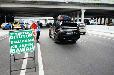 Petugas mengatur lalu lintas di depan pintu masuk tol layang MBZ yang ditutup situasional, Bekasi, Jawa Barat, Kamis (28/4/2022).
