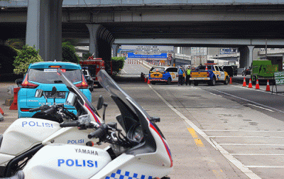 Petugas mengatur arus lalu lintas didekat pintu masuk Jalan Tol Layang Mohammed Bin (MBZ), Jakarta-Cikampek di kawasan Jatibening, Bekasi, Jawa Barat.