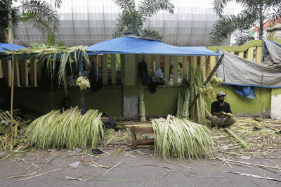 Pedagang musiman saat membuat anyaman kulit ketupat di Pasar Pondok Gede, Bekasi, Jawa Barat, Sabtu (30/4/2022).