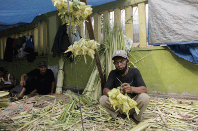 Pedagang musiman saat membuat anyaman kulit ketupat di Pasar Pondok Gede, Bekasi, Jawa Barat, Sabtu (30/4/2022).
