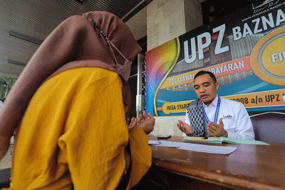Warga saat membayar zakat di Stand Pelayanan Zakat Masjid Istiqlal, Jakarta Pusat, Jumat (29/4/2022).