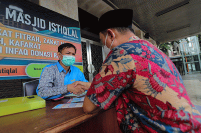 Warga saat membayar zakat di Stand Pelayanan Zakat Masjid Istiqlal, Jakarta Pusat, Jumat (29/4/2022).