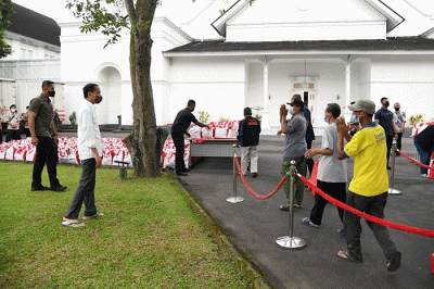 Presiden Joko Widodo membagikan paket sembako bagi masyarakat di sekitar Gedung Agung, Istana Kepresidenan Yogyakarta, pada Sabtu, 30 April 2022.