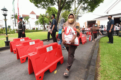 Presiden Joko Widodo membagikan paket sembako bagi masyarakat di sekitar Gedung Agung, Istana Kepresidenan Yogyakarta, pada Sabtu, 30 April 2022.