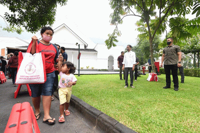 Presiden Joko Widodo membagikan paket sembako bagi masyarakat di sekitar Gedung Agung, Istana Kepresidenan Yogyakarta, pada Sabtu, 30 April 2022.