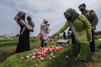 Umat muslim berdoa di dekat makam keluarganya saat melakukan ziarah kubur di Blok Syuhada, Tempat Pemakaman Umum (TPU) Rorotan, Jakarta Utara, Senin (2/5/2022).